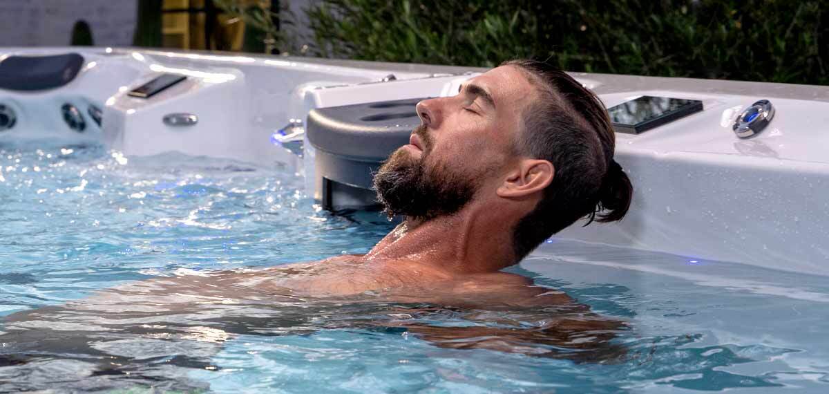 Michael Phelps relaxing in a therapy seat of a swim spa.