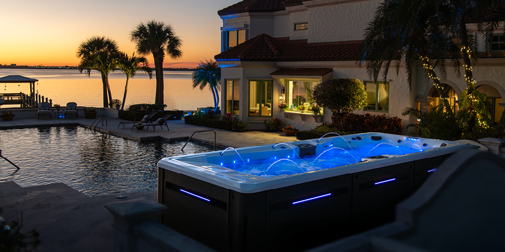 Swim spa with LEDs on at sunset.